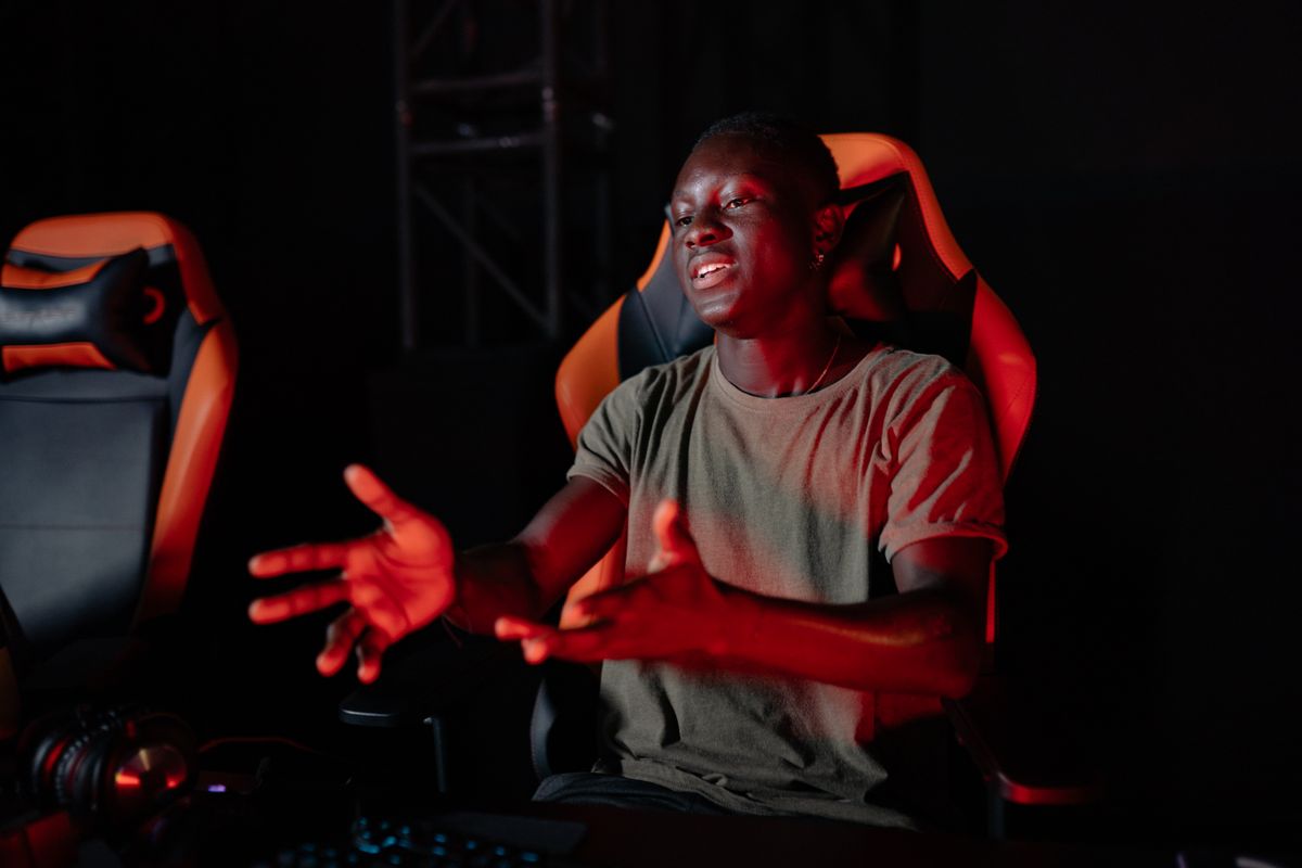 A tall person seated at a gaming desk setup