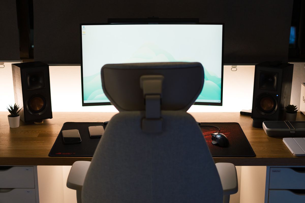 A person adjusting desk height at a gaming setup