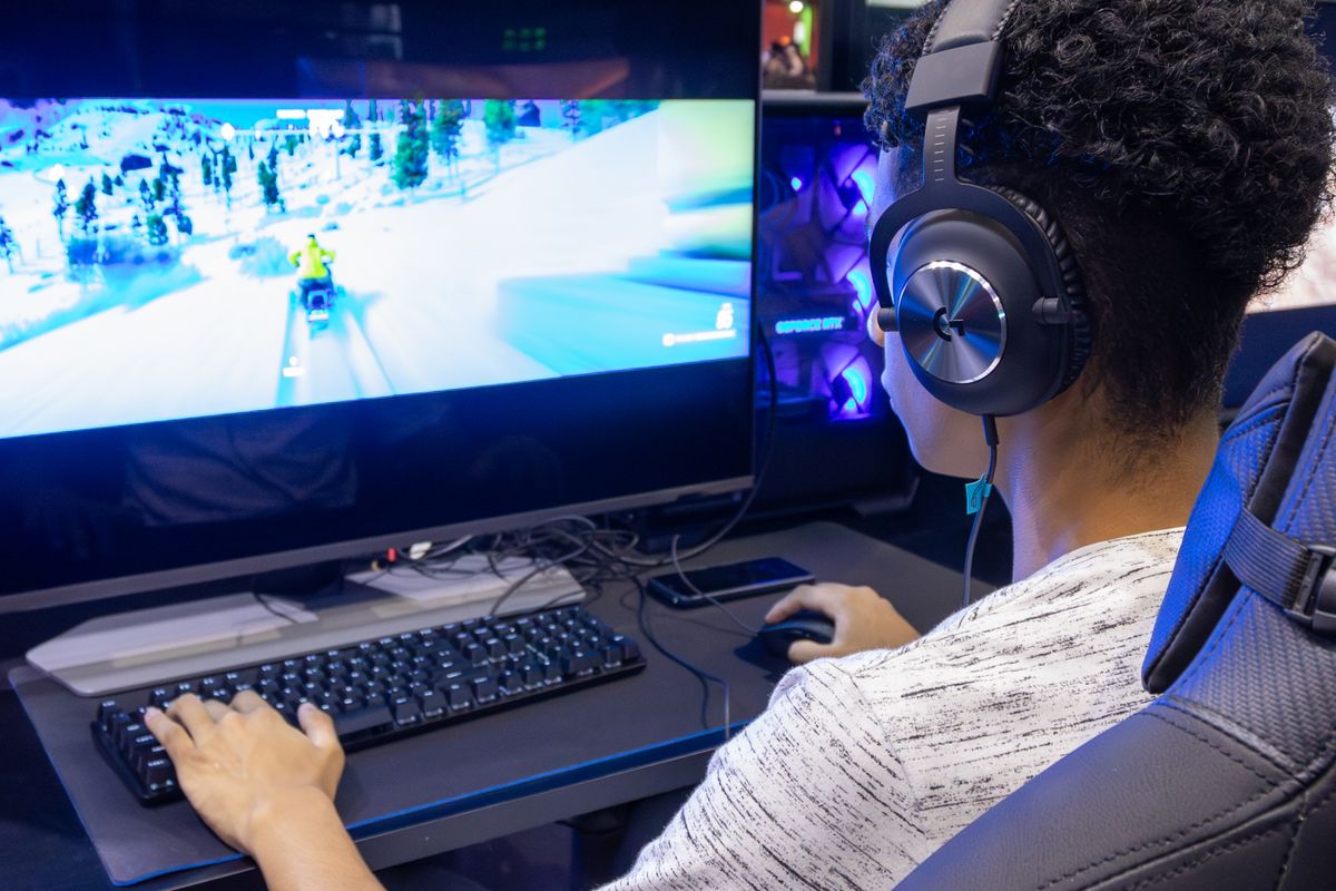 A well-used gaming chair showing wear on armrest