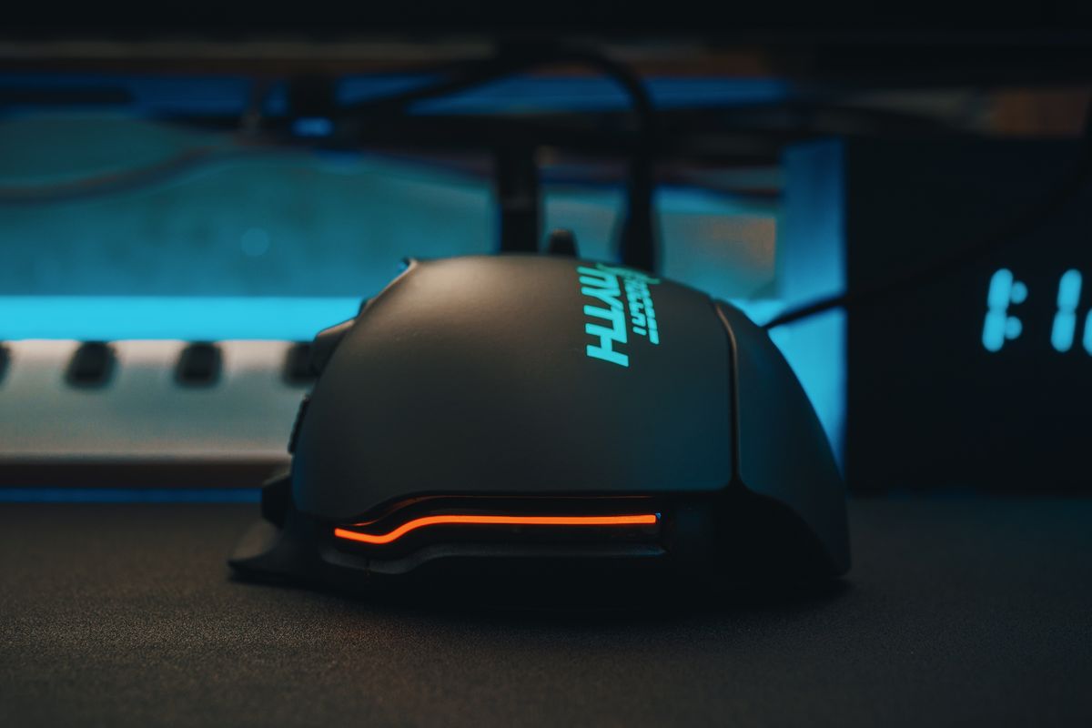A light wireless gaming mouse on a dark mousepad