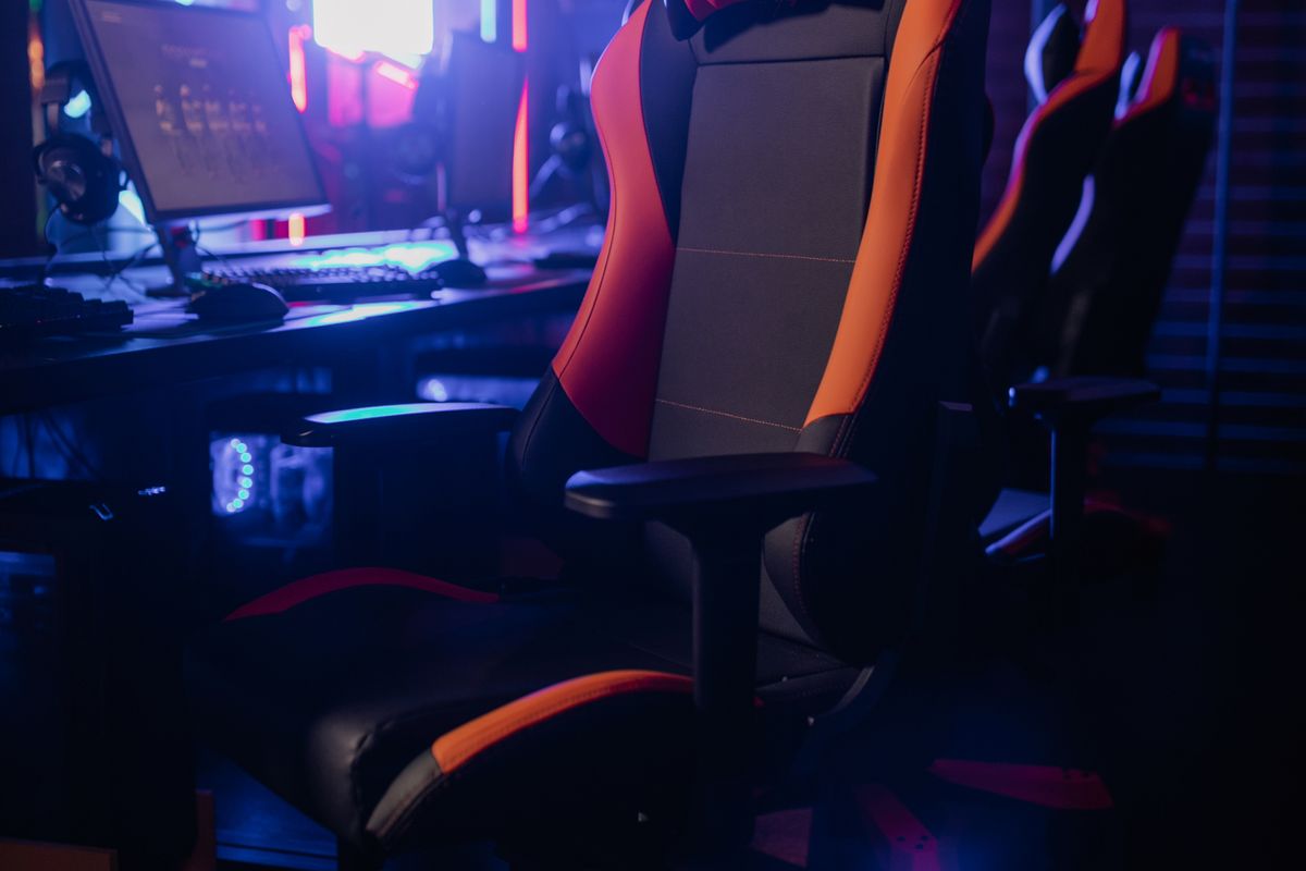A black gaming chair with integrated lumbar support at a desk